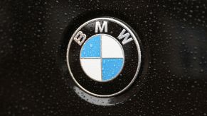 A BMW logo on a wet black car.