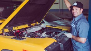A man performing scheduled vehicle maintenance on a car