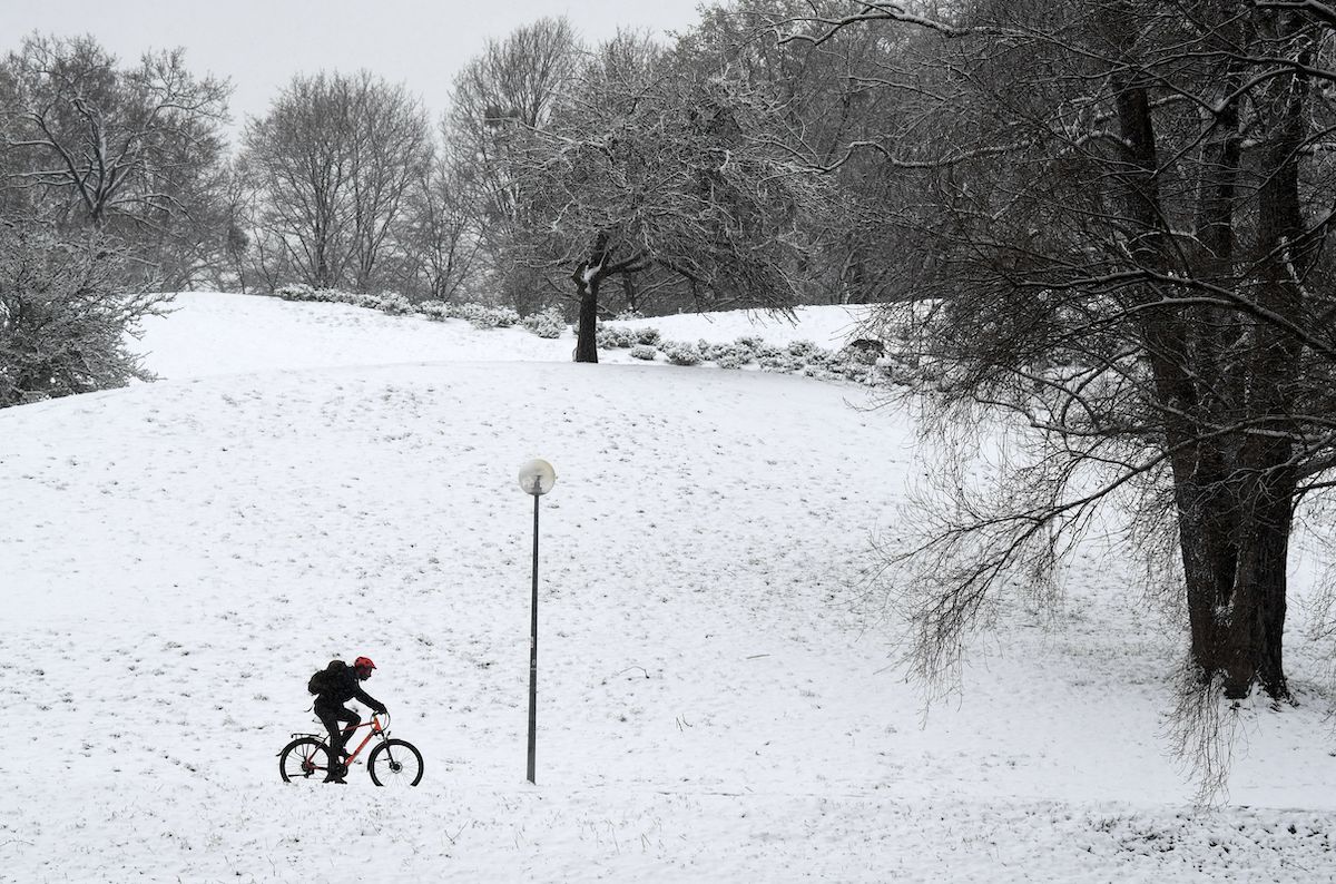A snow covered scene while someone is riding bike, such as the Engine Pro E-Bike or a normal pedal bike.