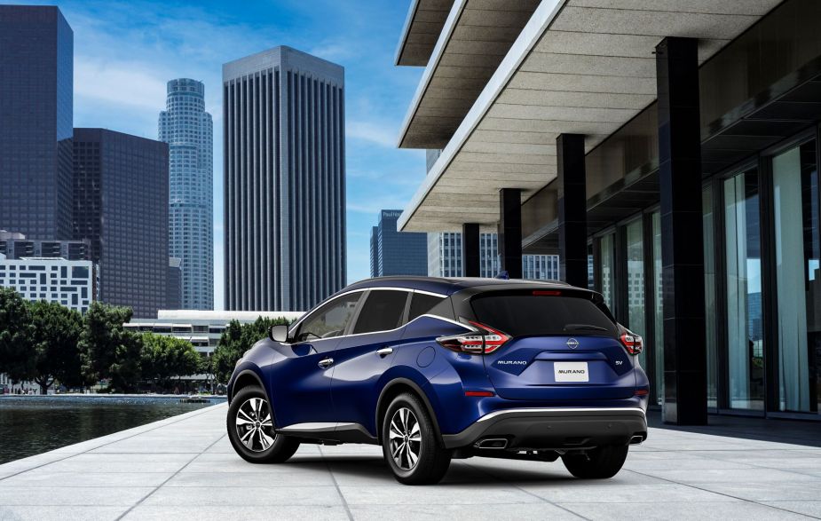 A blue 2023 Nissan Murano midsize SUV parked on a marble plaza near a pool in an urban city