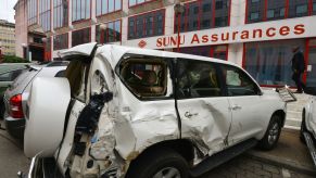A damaged SUV parked in front of a SUNU Assurances insurance group office in Abidjan