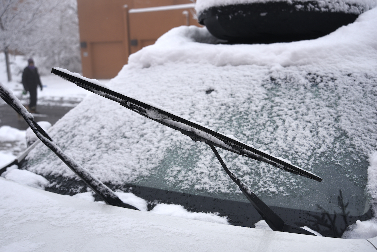 A car is covered with snow and ice after a late autumn storm in New Mexico.