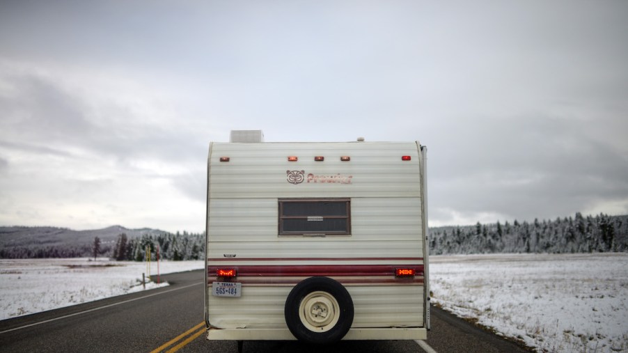 An RV driving through a wintery scene, possibly preparing for parking your RV for the winter.