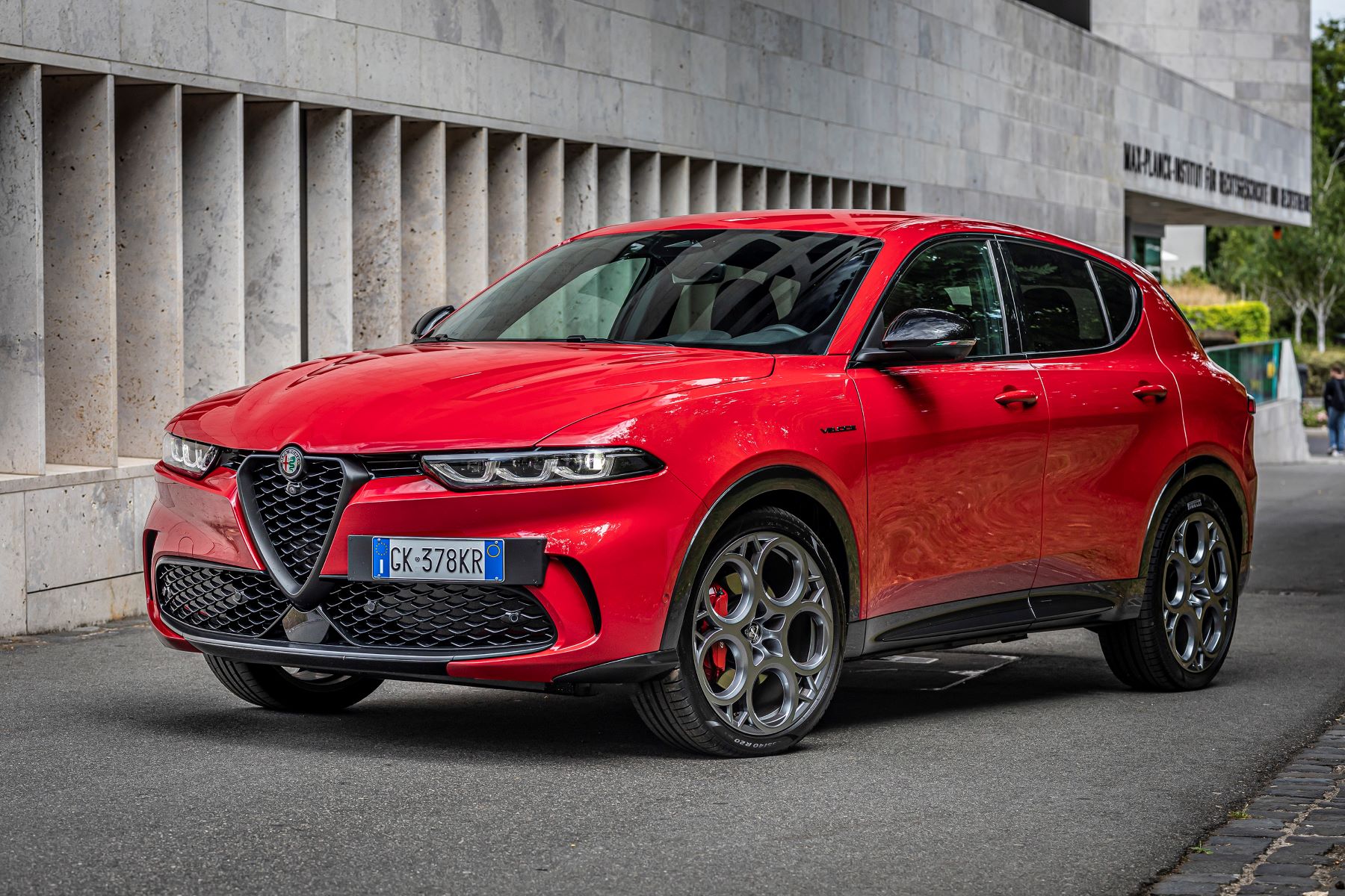 A red 2023 Alfa Romeo Tonale Veloce plug-in hybrid electric vehicle (PHEV) compact SUV model