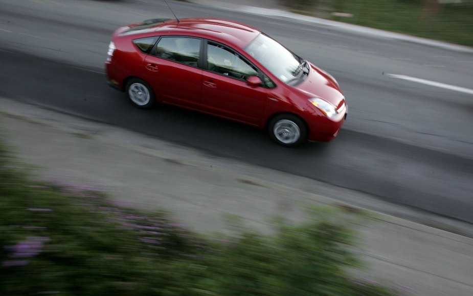 A Toyota Prius hybrid vehicle is seen driving down the street.