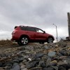 A red Toyota RAV4 is shown climbing a rocky hill