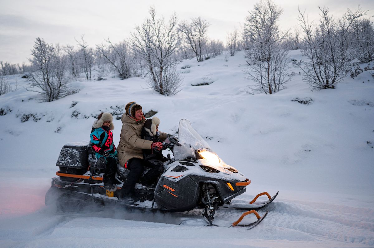 A family riding on a snowmible.