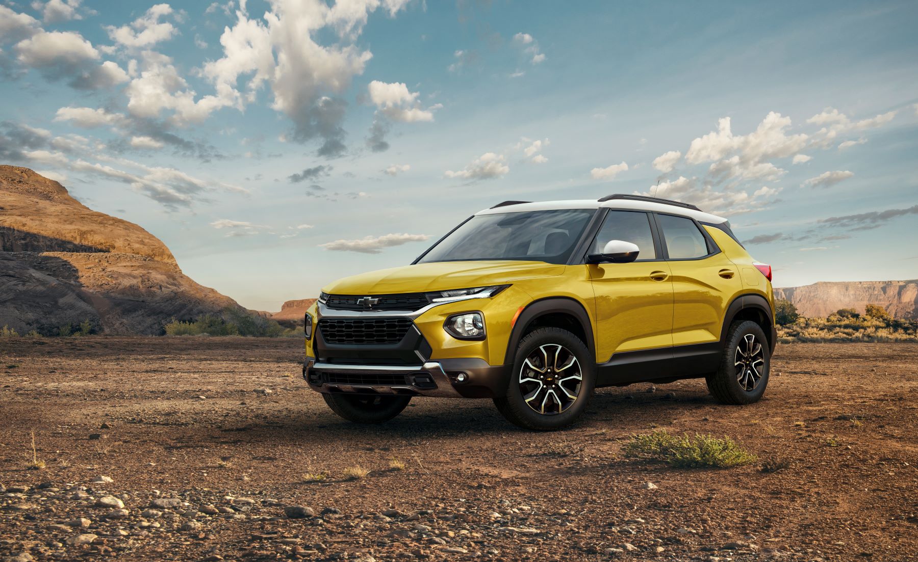 A yellow 2023 Chevy Trailblazer subcompact SUV model parked on a desert dirt plain