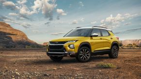 A yellow 2023 Chevy Trailblazer subcompact SUV model parked on a desert dirt plain