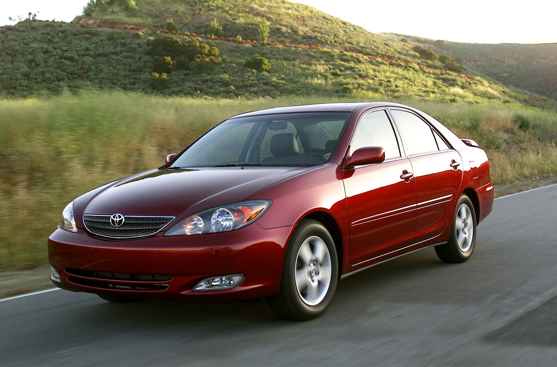 A dark red Toyota Camry midsize sedan model from the 2002 to 2006 model year generation