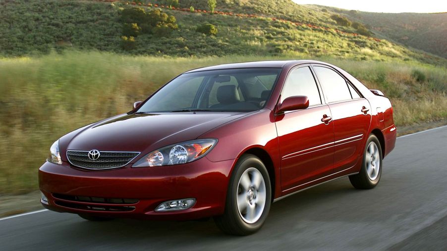 A dark red Toyota Camry midsize sedan model from the 2002 to 2006 model year generation