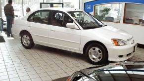 A white 2003 Honda Civic Hybrid at a car dealership.