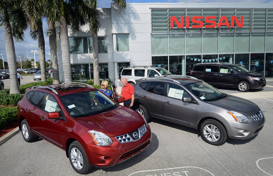 A pair of 2013 Nissan Rogue SUVs sit at a dealership, it might be a good used SUV.