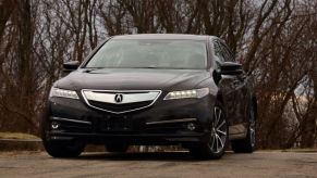 A black 2015 Acura TLX driving down the road