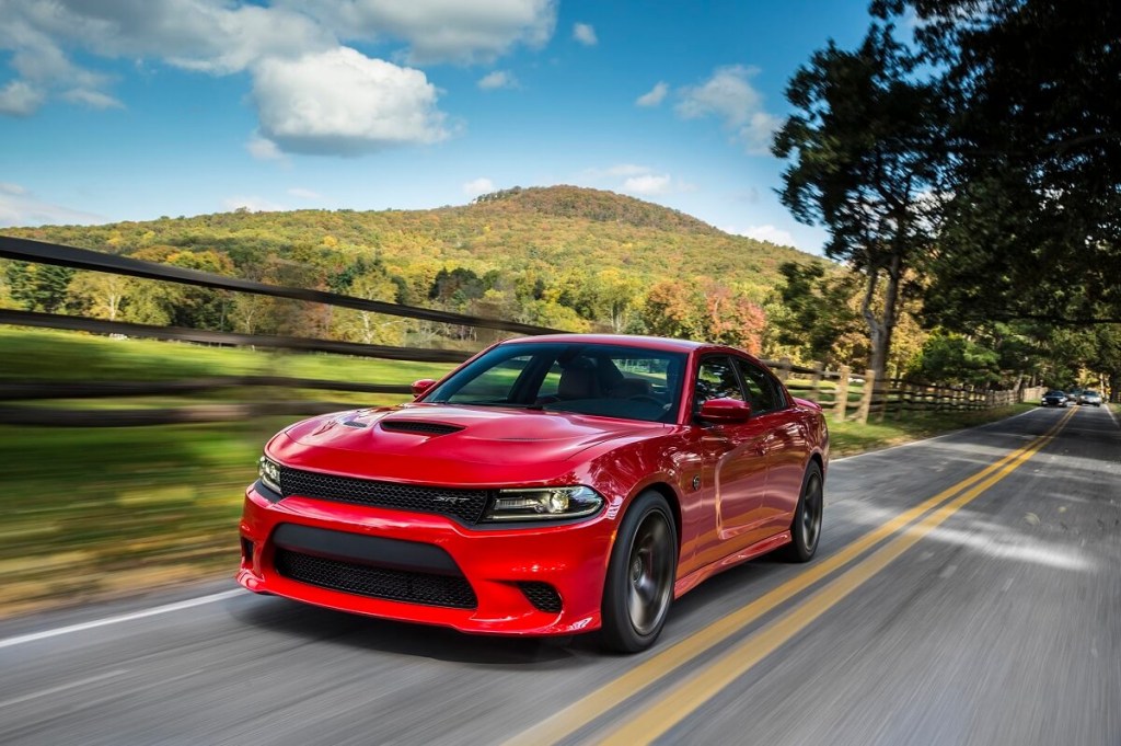 A standard body 2017 Dodge Charger SRT Hellcat cruises a country road.