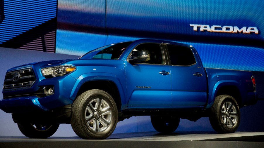 A blue 2016 Toyota Tacoma midsize pickup truck is on display.