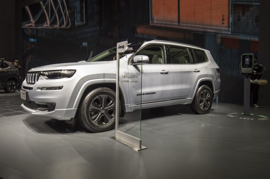Silver plug-in hybrid foreign market Jeep Commander SUV at an auto show in China.