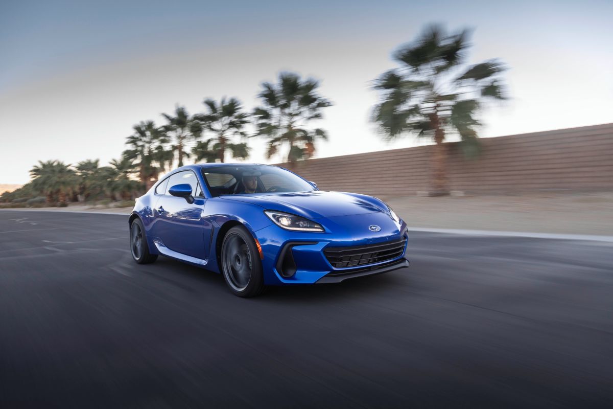 A blue redesigned 2022 Subaru BRZ driving down a highway.