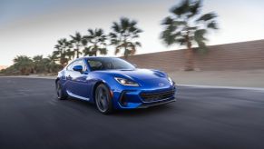 A blue redesigned 2022 Subaru BRZ driving down a highway.
