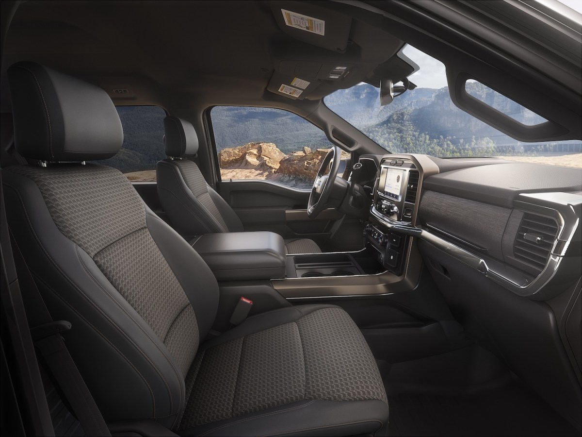 The interior of Ford's entry-level F-150 XL trim outfitted with cloth seats, a mountain range visible outside the window.