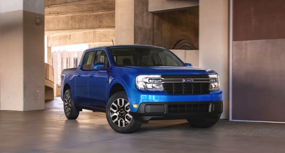 A blue 2023 Ford Maverick small pickup truck is driving. 