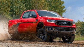A red 2023 Ford Ranger midsize pickup truck is driving off-road.