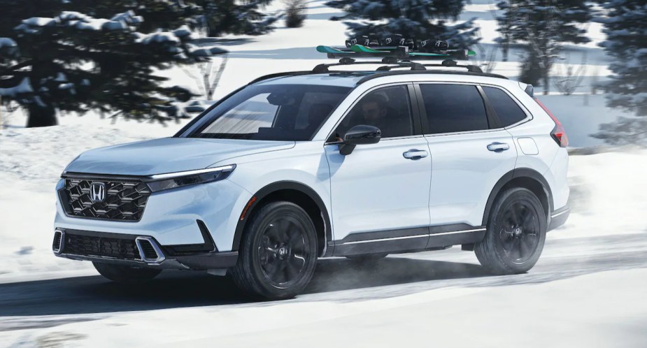 A white 2023 Honda HR-V subcompact SUV is driving in the snow. 