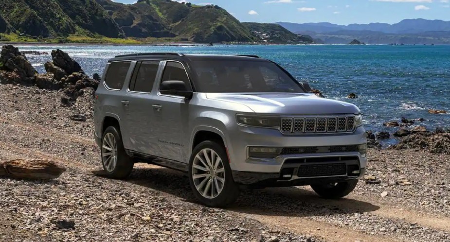 A gray 2023 Jeep Grand Wagoneer large luxury SUV is parked off the road. 
