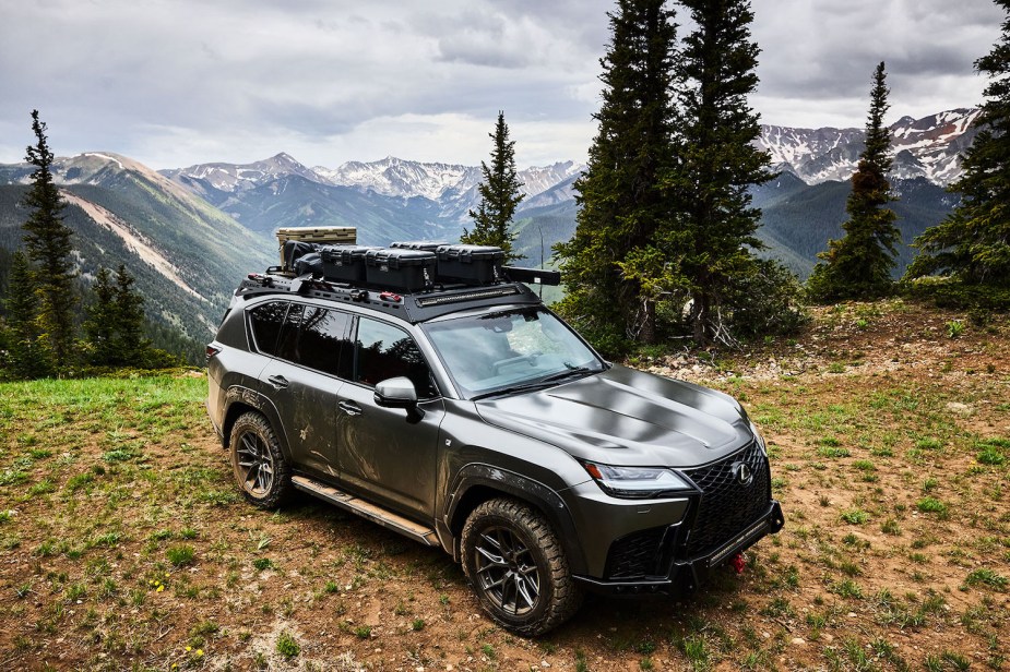 A Lexus concept SUV complete with a roof ski rack, parked on a mountain top with snow-capped peaks visible in the background.