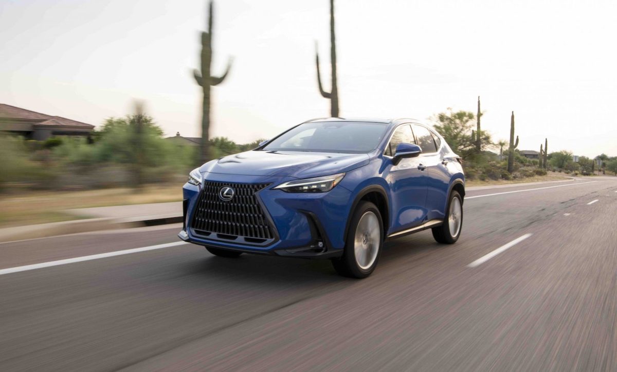 A blue Lexus NX350h hybrid crossover SUV driving through the desert for a promotional photo, cacti visible in the background.