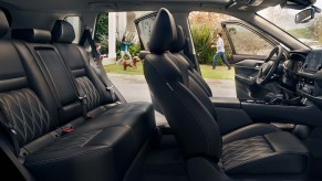 A blacked out interior of a 2023 Nissan Rogue with leather seats for five