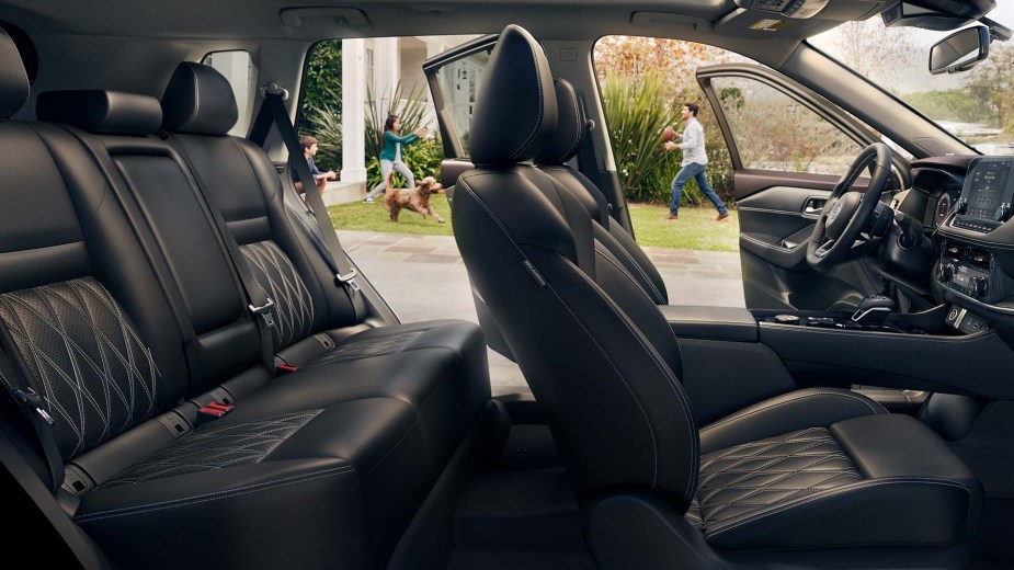 A blacked out interior of a 2023 Nissan Rogue with leather seats for five