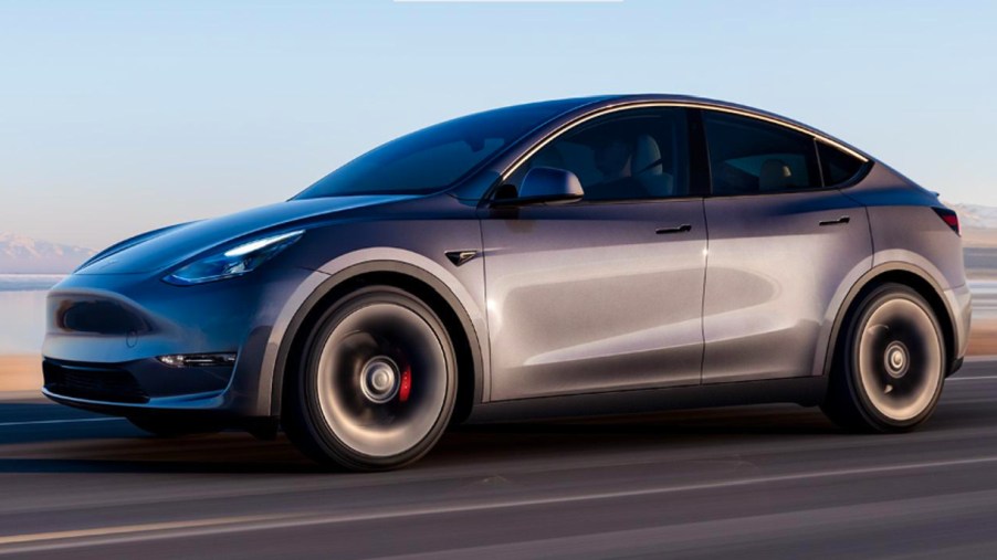 A gray 2023 Tesla Model Y is driving on the road.