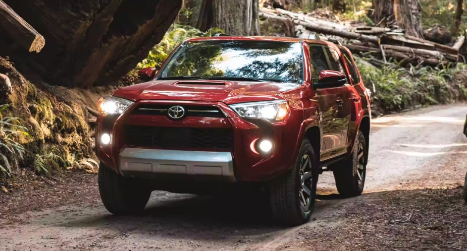 A red 2023 Toyota 4Runner midsize SUV is parked off-road. 