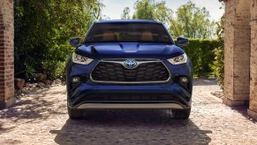 A blue 2023 Toyota Highlander Hybrid midsize hybrid SUV is parked.