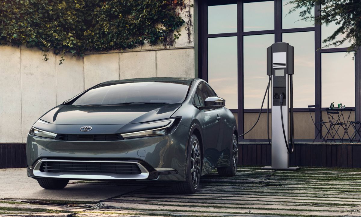 A 2023 Toyota Prius Prime charging in a driveway.
