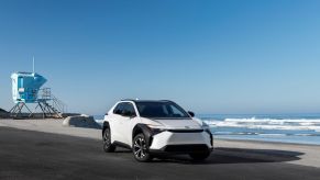 A 2023 Toyota bz4X compact electric SUV model in Wind Chill Pearl parked on a beach near a lifeguard station
