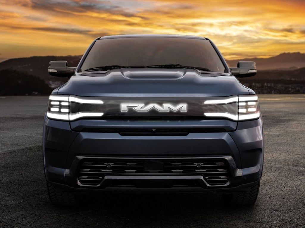 The front of the 2025 Ram 1500 REV at dusk with the headlights on 