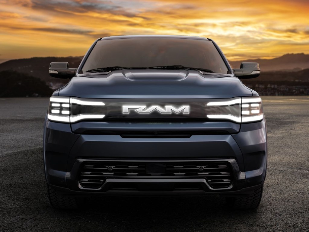 The front of the 2025 Ram 1500 REV at dusk with the headlights on