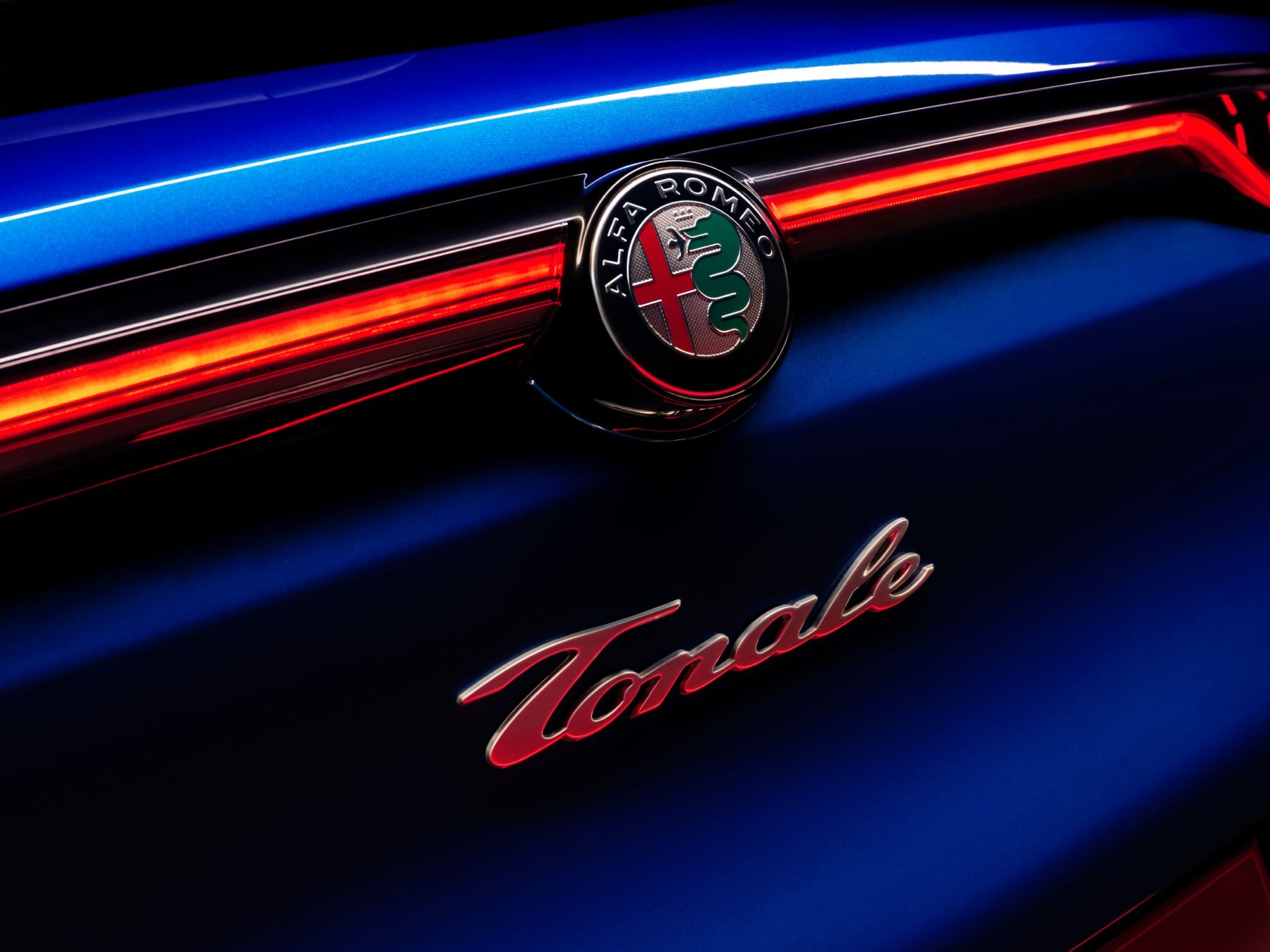 The logo and badging of an Alfa Romeo Tonale luxury plug-in hybrid electric vehicle (PHEV) model