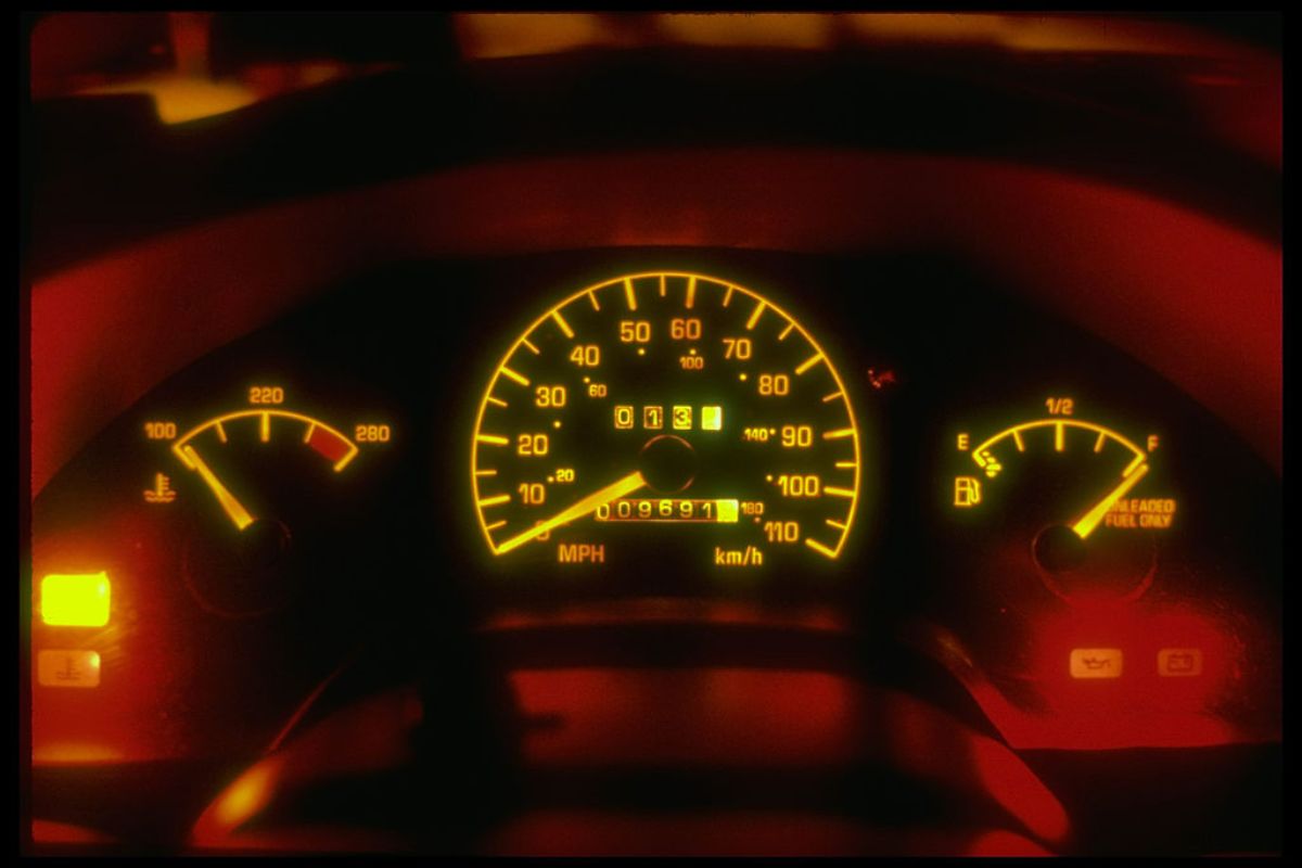 A car dashboard with lights glowing at night.