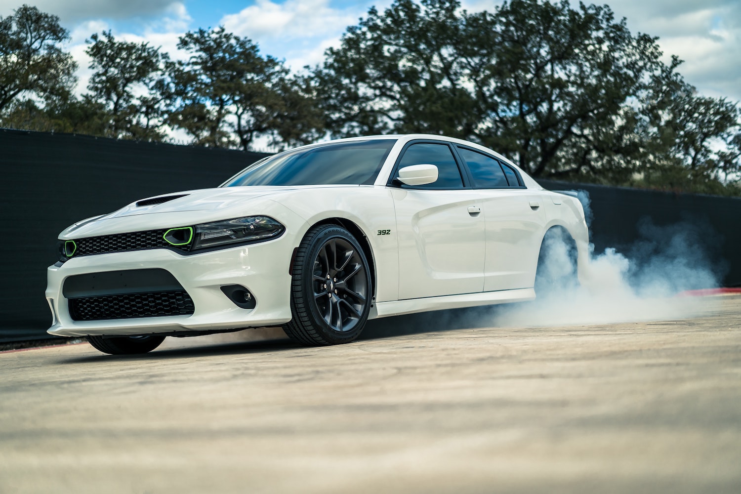 A white Dodge Charger spinning its wheels, showing off just how much horsepower it actually has