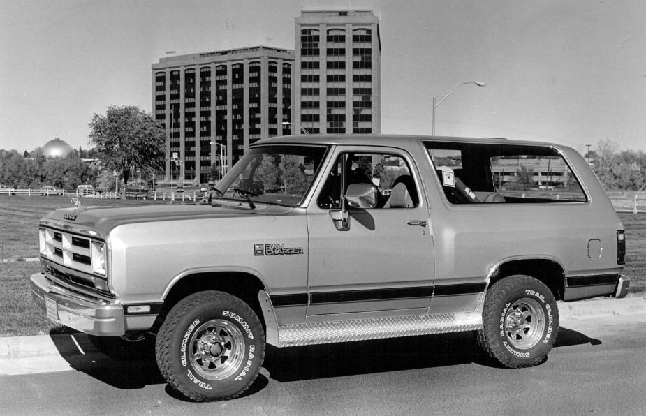 Black and white photo of a Ram Charger SUV, a building visible in the background.
