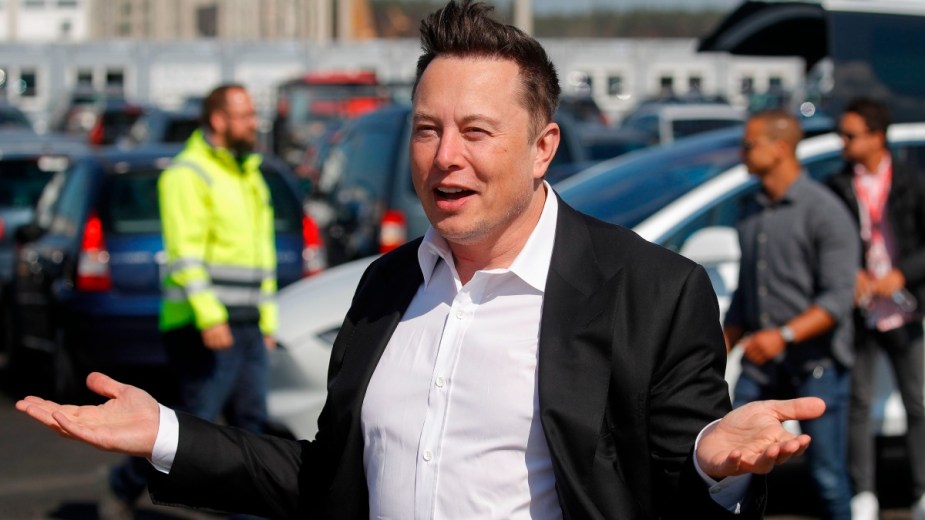 Elon Musk standing near Tesla vehicle, showing how customers cancel orders due to his Twitter drama