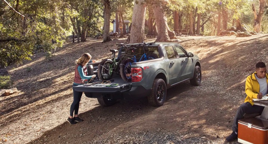 A blue 2023 Ford Maverick is parked outdoors with its truck bed open.