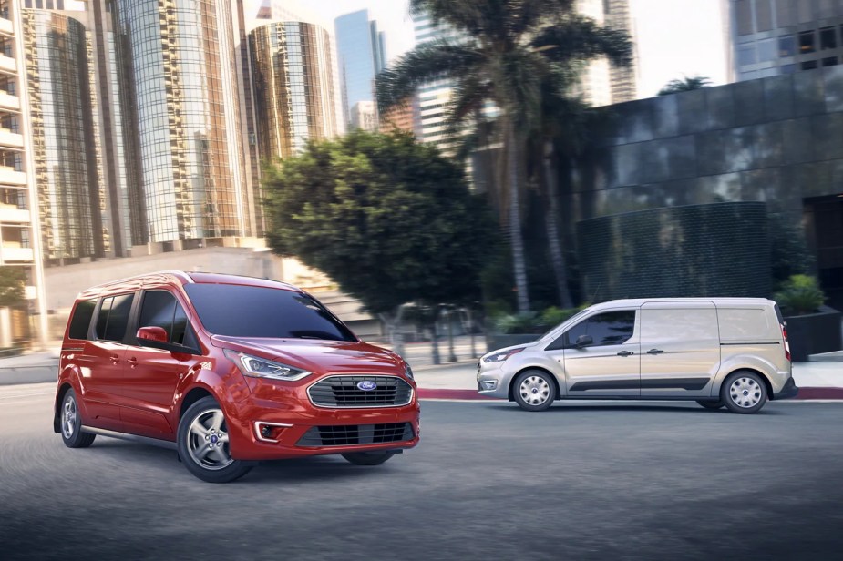 A pair of 2023 Ford Transit vans sit in an urban environment. 