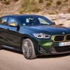 Front angle view of green 2023 BMW X2 small luxury SUV, the cheapest new BMW car