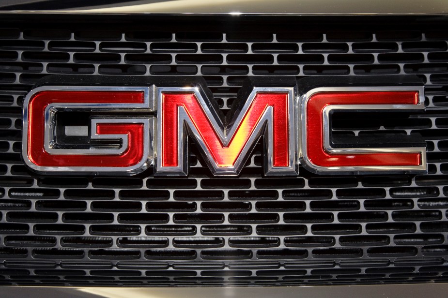 Closeup of a red GMC logo on a pickup truck grill.