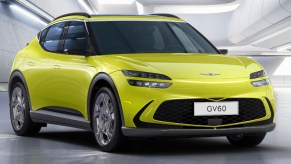 A green 2023 Genesis GV60 small electric SUV is parked.