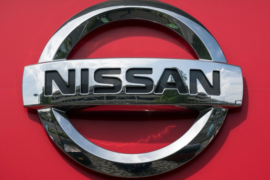 Nissan logo against a red background, makers of the Nissan model with the most reliability improvement.